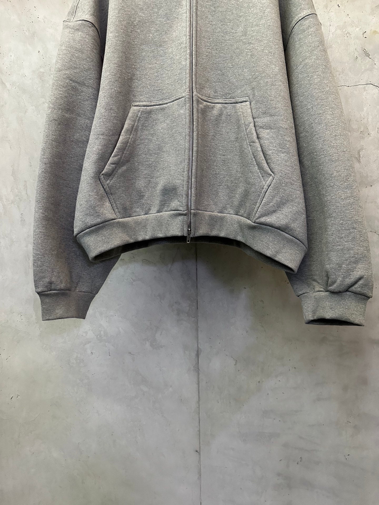 Balenciaga gray zip-up hoodie front view with hood and kangaroo pockets, ribbed hem.