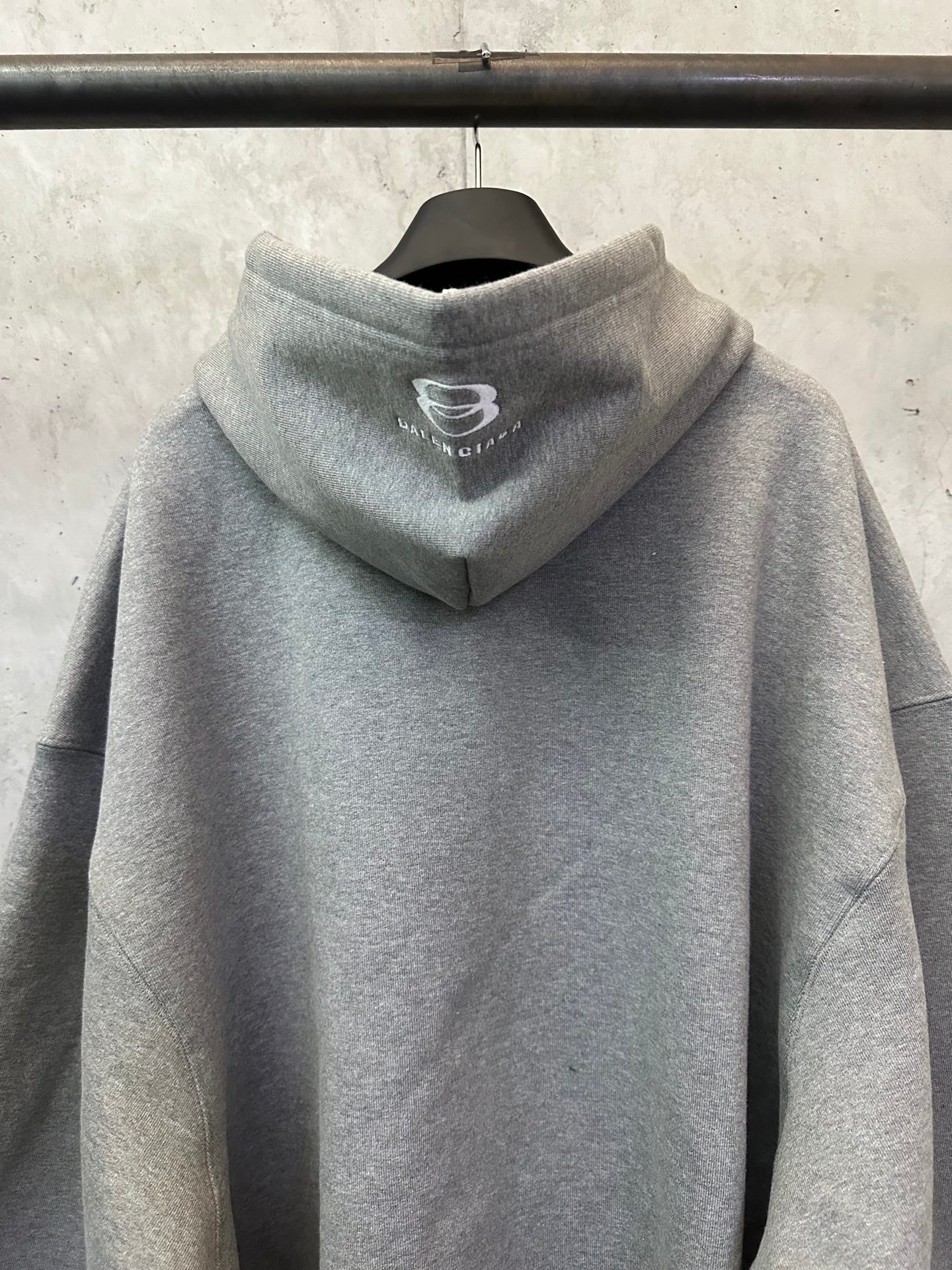 Balenciaga gray hooded sweatshirt with small chest logo, long sleeves, and ribbed cuffs.
