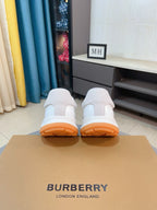 Burberry white leather sneakers with back view and orange rubber soles