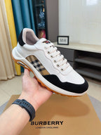 White and dark lace-up sneakers with plaid side panel and orange outsole