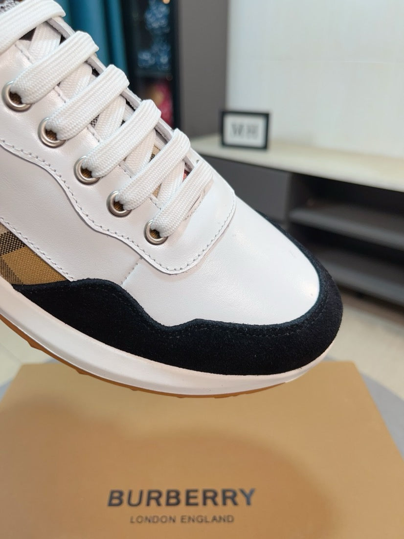 Close-up of white lace-up sneaker with beige and black plaid panel and black trim
