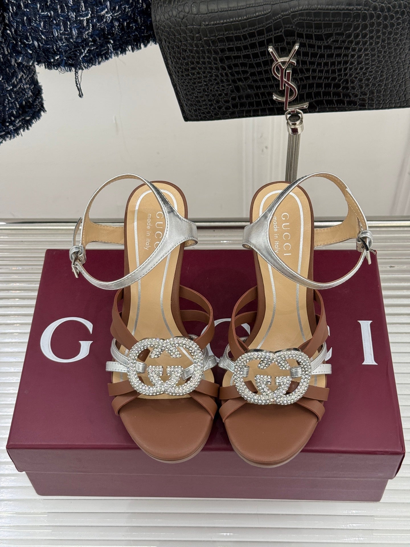 Gucci heeled sandals pair, silver strappy uppers with jeweled G buckle, tan footbed