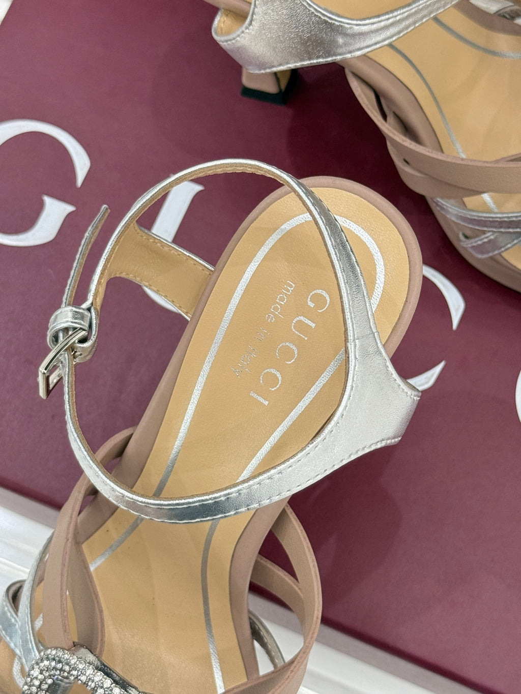 Gucci heeled sandal showing back strap and silver ankle strap on light beige footbed