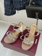 Gucci heeled sandals with silver toe straps and crystal-style heart buckle on beige base