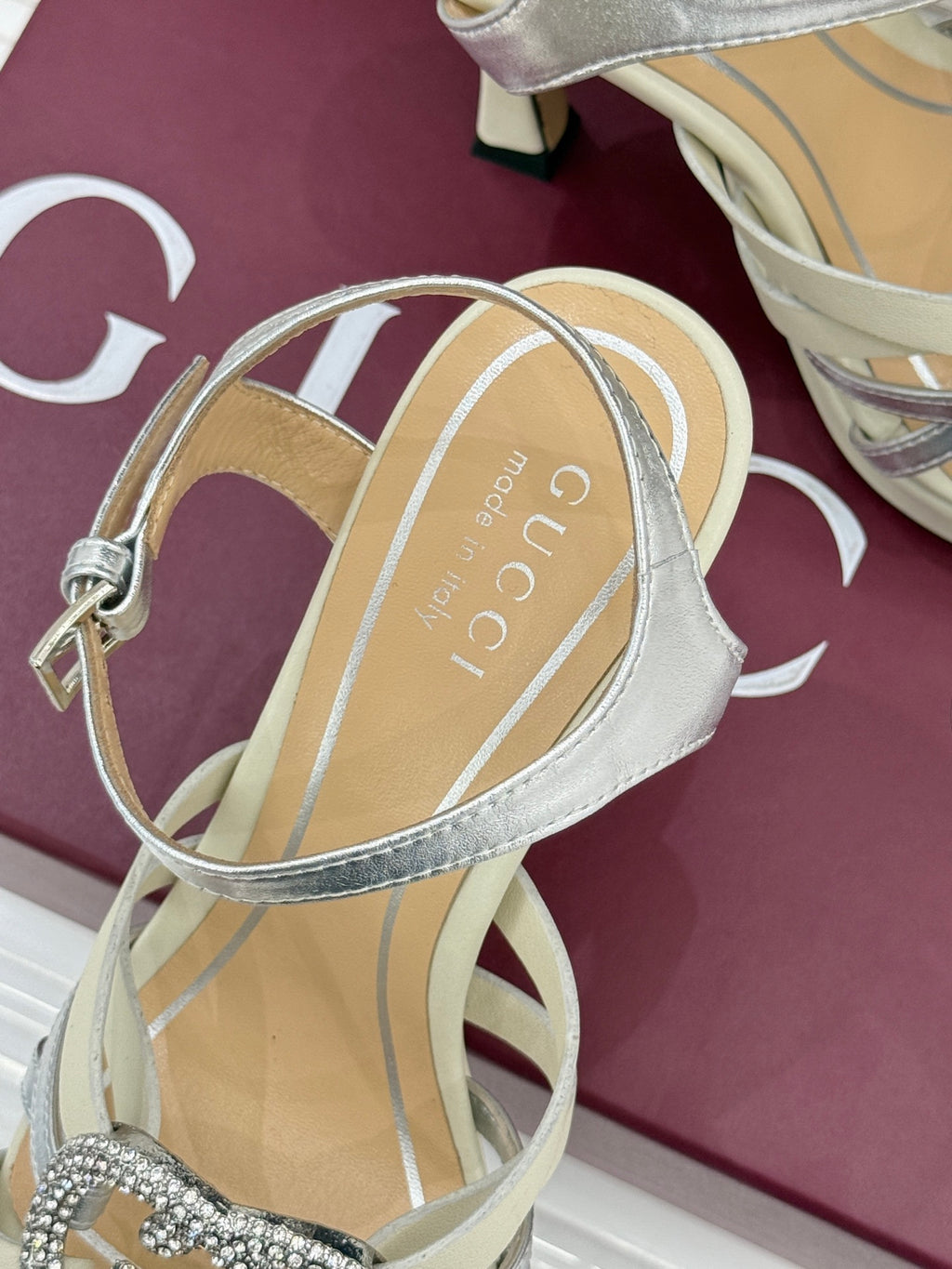 Gucci ladies sandal close-up of silver ankle strap and cream footbed