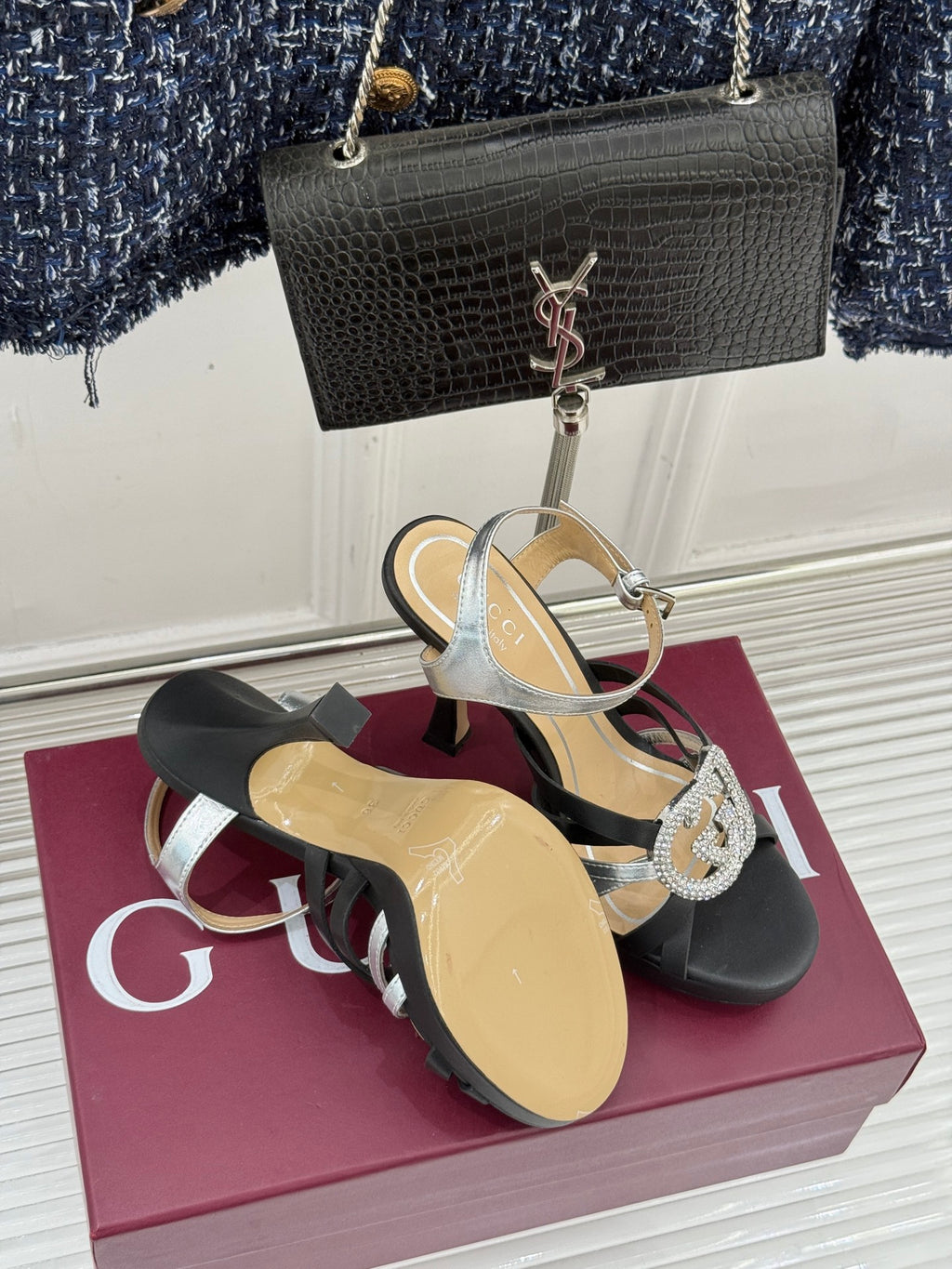 Gucci heeled sandals with black straps and silver trim, rhinestone buckle at front