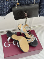 Gucci heeled sandals with black straps and silver trim, rhinestone buckle at front