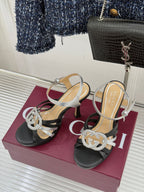 Gucci heeled sandals pair with black straps, silver trim, and rhinestone G-style buckle