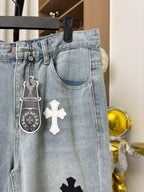 Light wash denim pants with belt loops and hanging cross and charm details