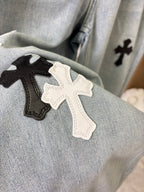 Close-up of cross patches on light wash denim pant fabric