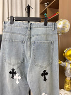 Light wash denim pants with back pockets and cross patches on front