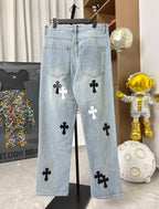 Light wash denim pants with side pockets and black and white cross patches