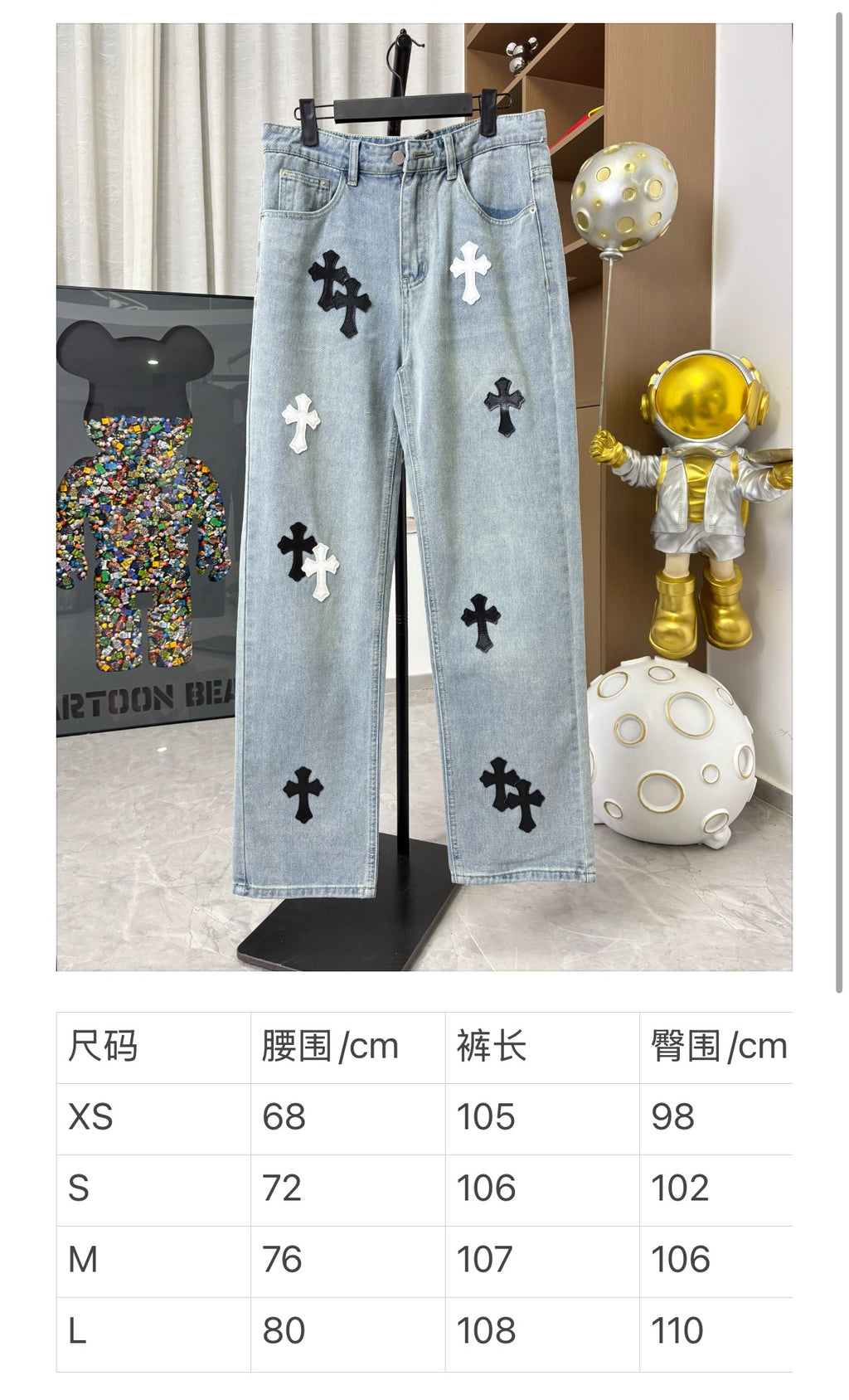 Light wash denim pants on display with black and white cross patches