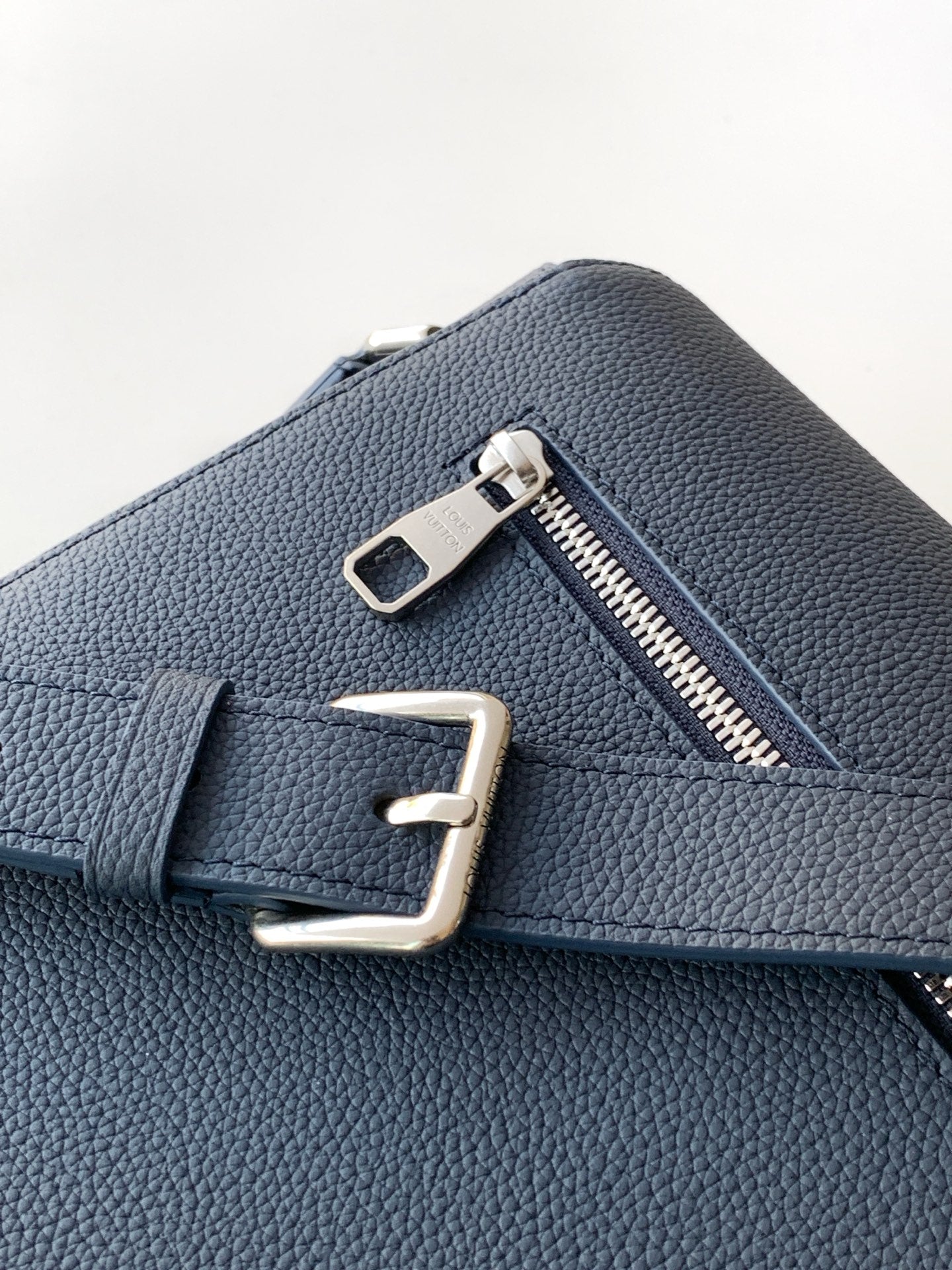 Louis Vuitton navy leather bag detail with silver zipper and metal D-ring