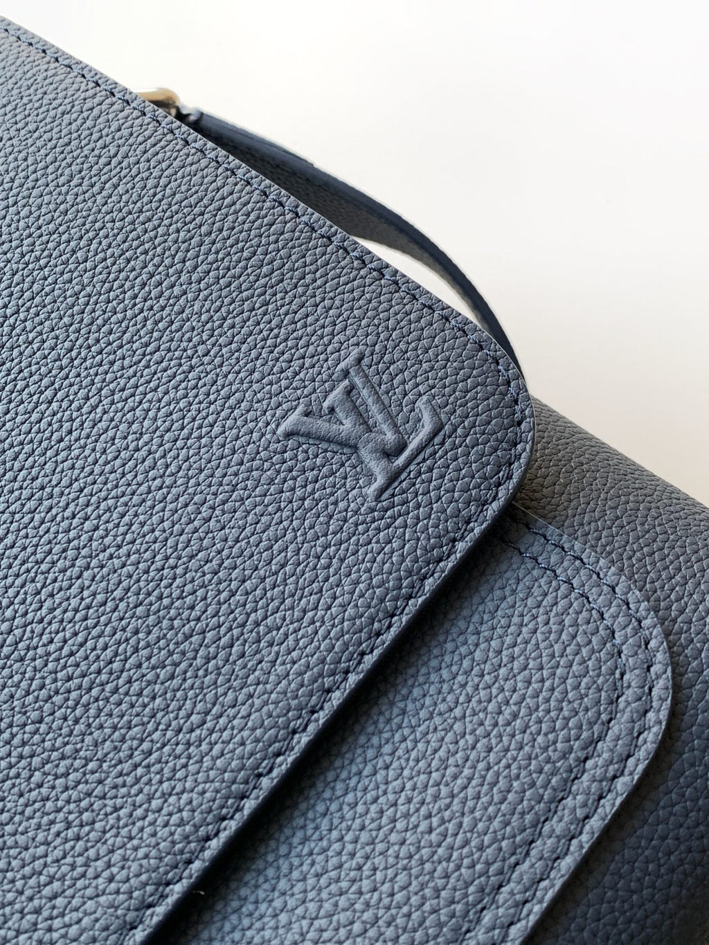 Louis Vuitton embossed logo on navy textured leather flap