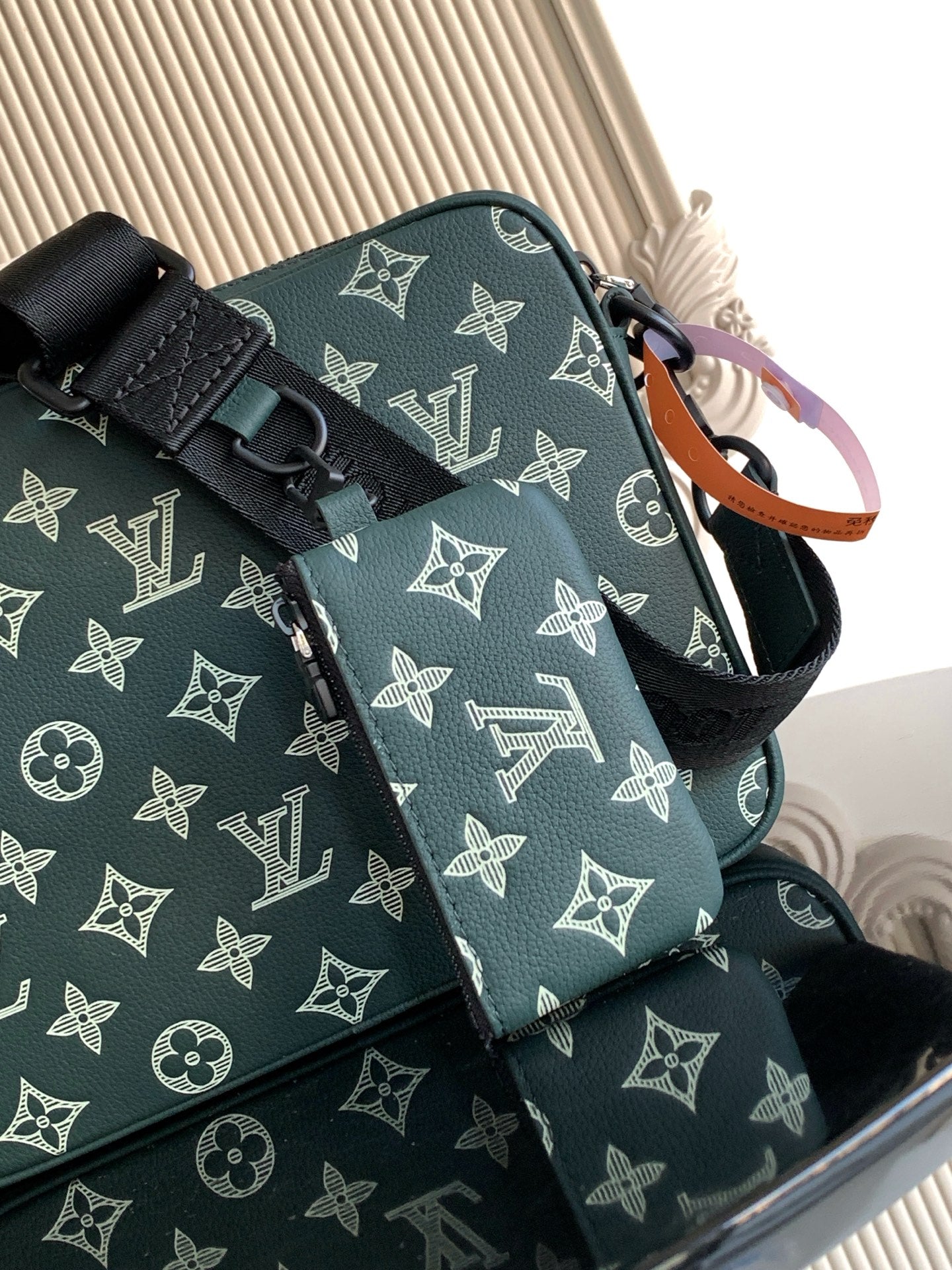 Louis Vuitton men's monogram bag in dark green, close-up of front panel and strap