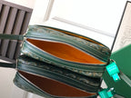 Green patterned crossbody bag set open to show orange interior lining and zipper tops