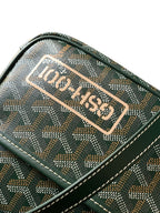 Green patterned bag close-up with brand patch label on the top flap and contrast stitching