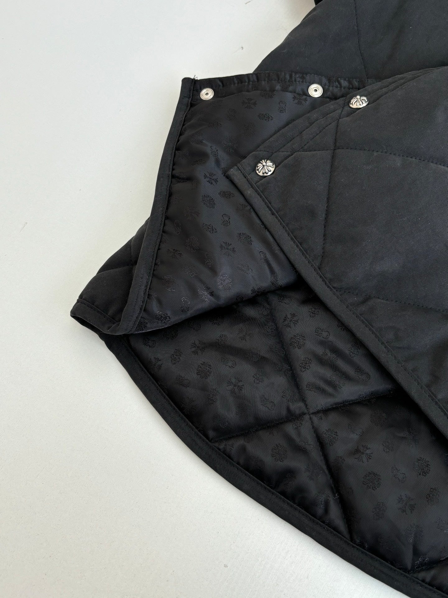 Black quilted jacket with snap details and patterned inner lining
