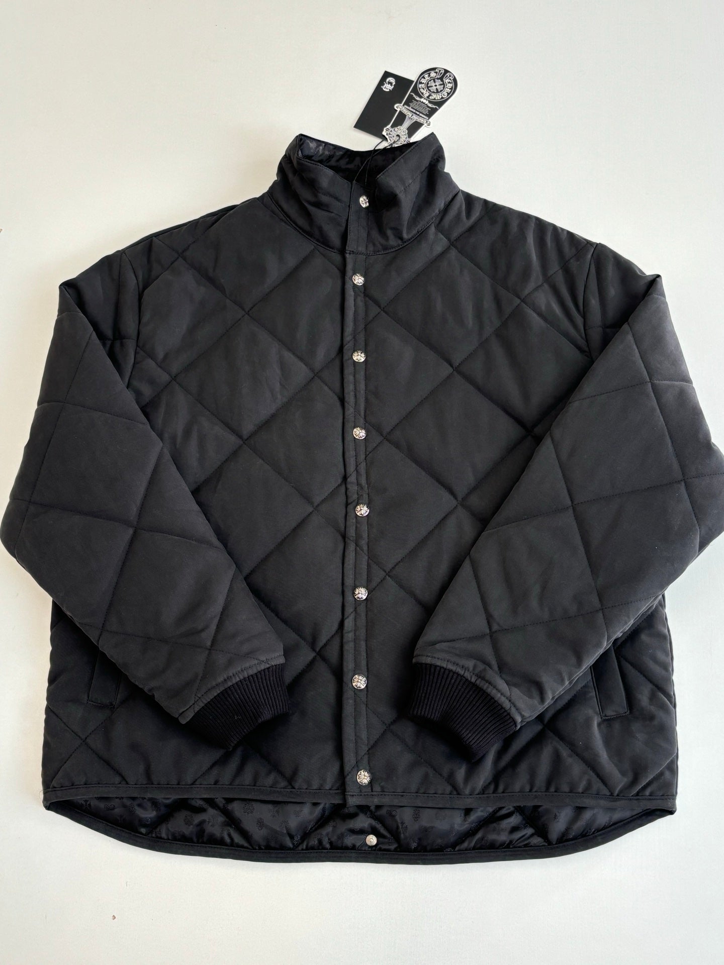 Black quilted hooded jacket with snap buttons