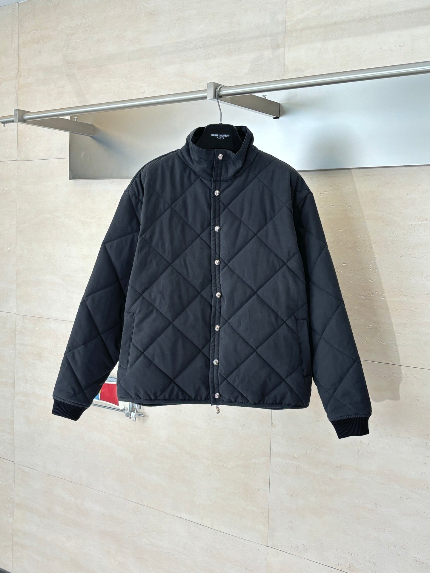 Black quilted long-sleeve jacket with snap-button front and stand collar