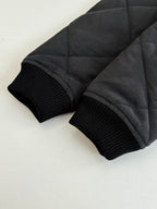 Black ribbed knit cuffs on quilted jacket sleeves