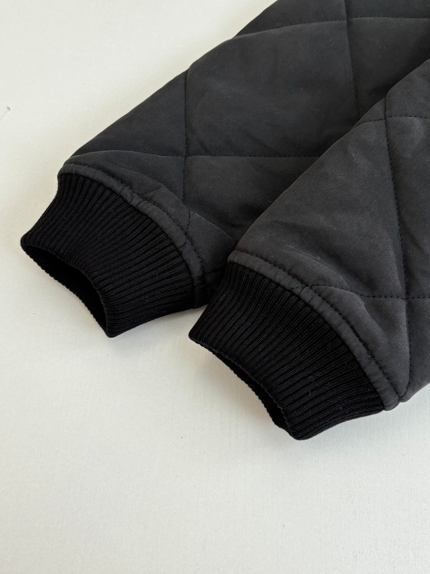 Black ribbed knit cuffs on quilted jacket sleeves