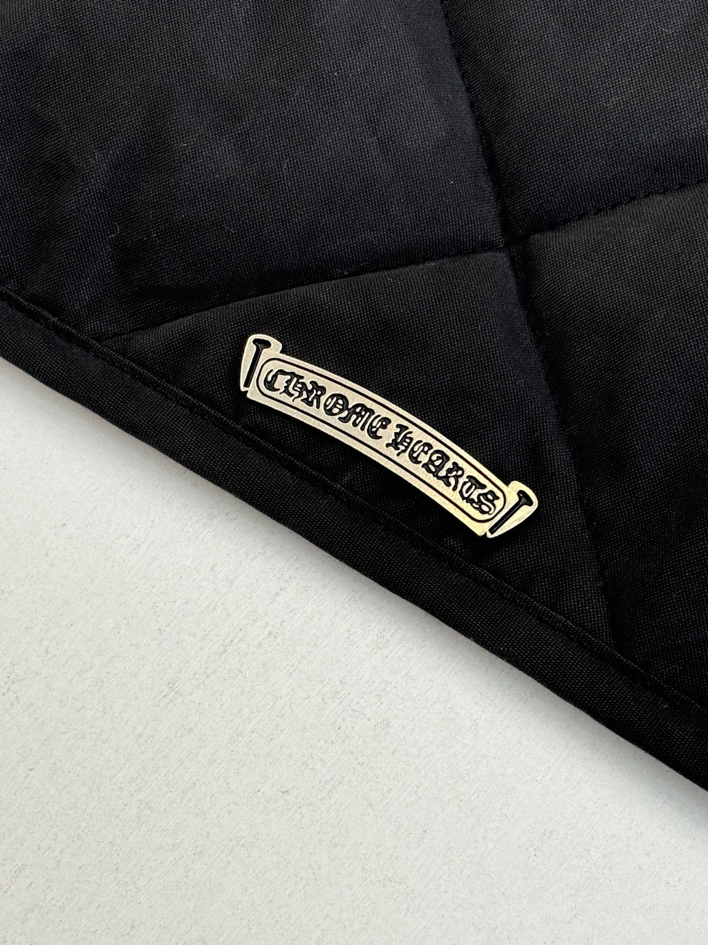 Black quilted jacket label patch near hem