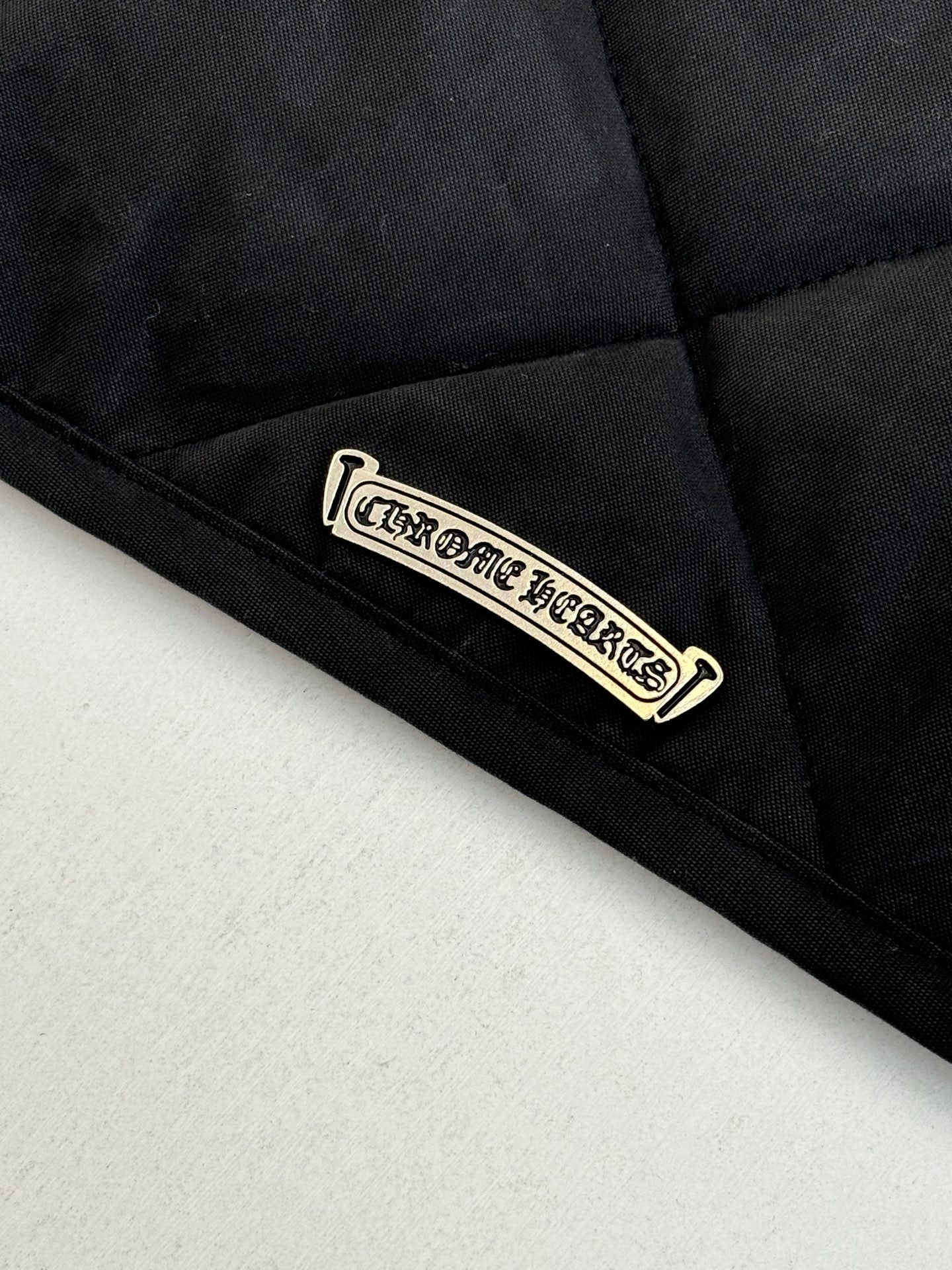 Black quilted jacket label patch near hem
