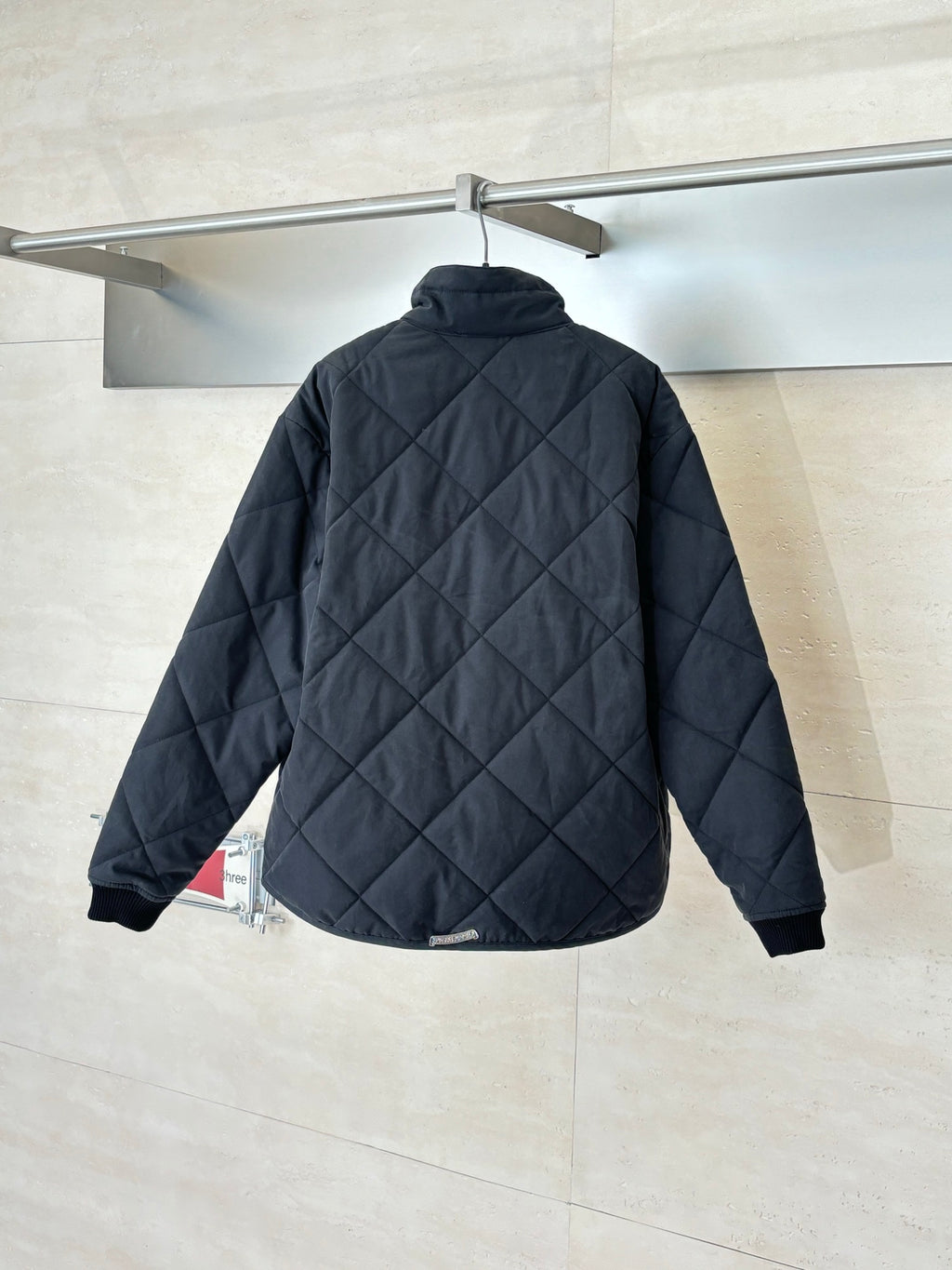 Black quilted jacket back view with stand collar and long sleeves