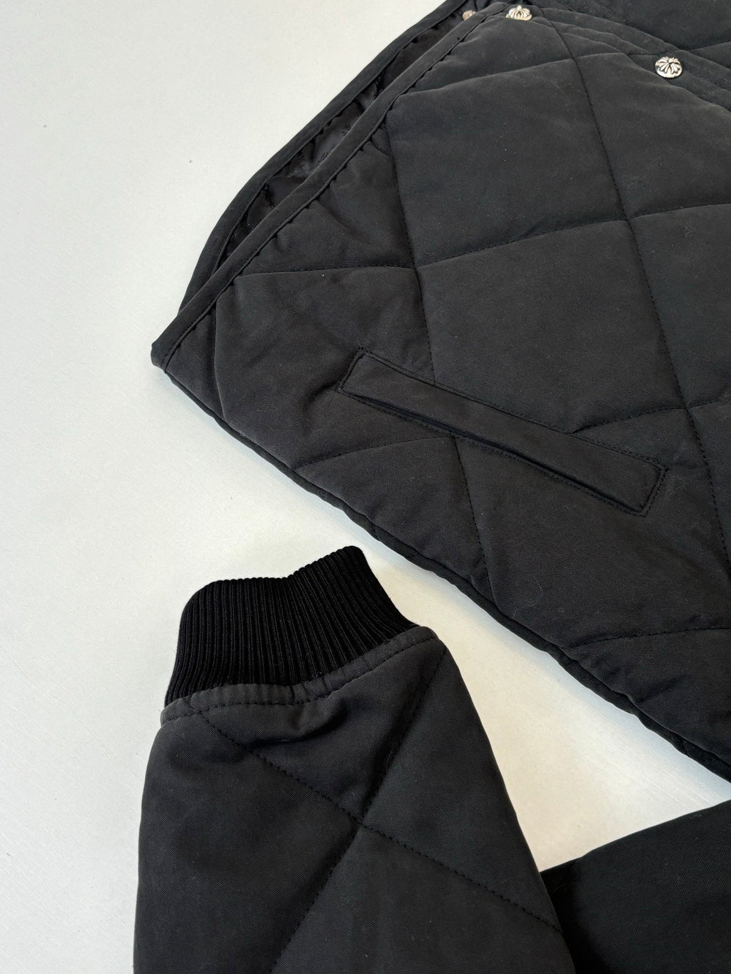 Black puffer jacket sleeve and side pocket with ribbed knit cuff