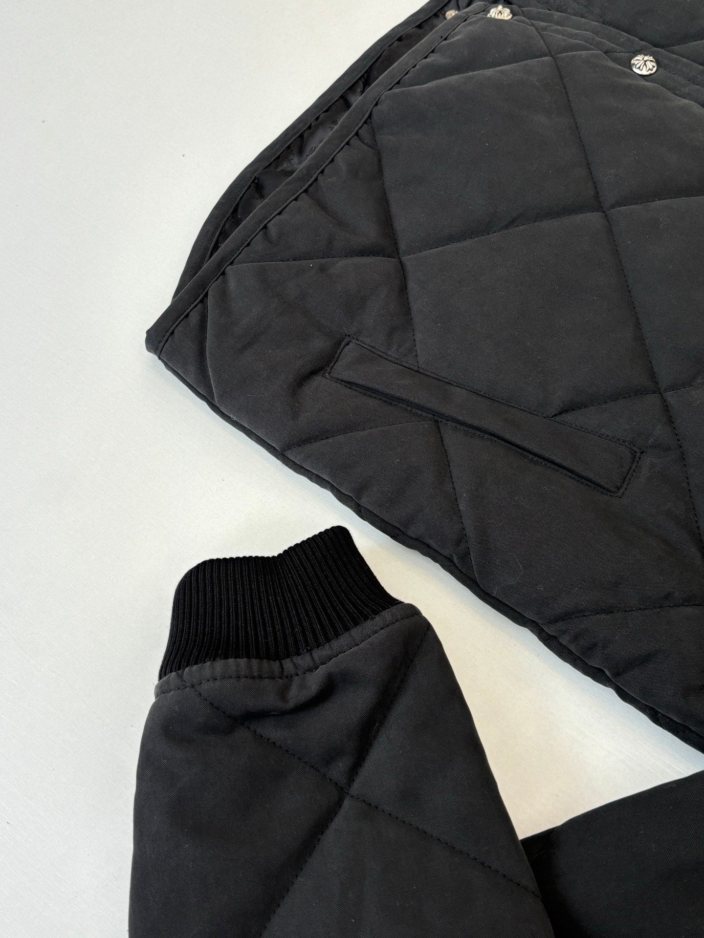 Black puffer jacket sleeve and side pocket with ribbed knit cuff