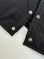 Black quilted jacket cuffs with snap buttons and small silver emblems