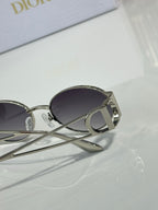 Silver-toned round sunglasses with dark tinted lenses and logo temple