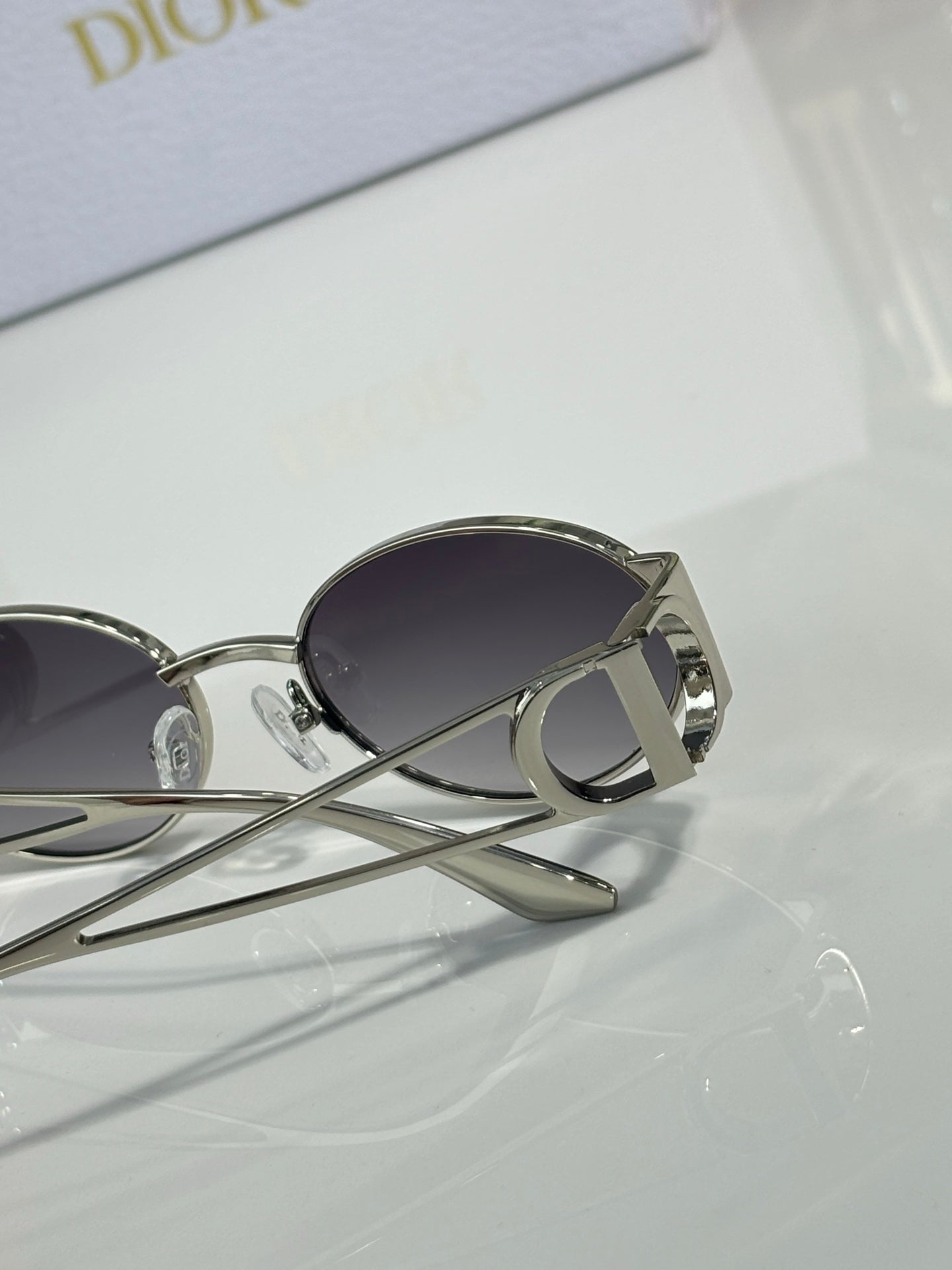 Silver-toned round sunglasses with dark tinted lenses and logo temple