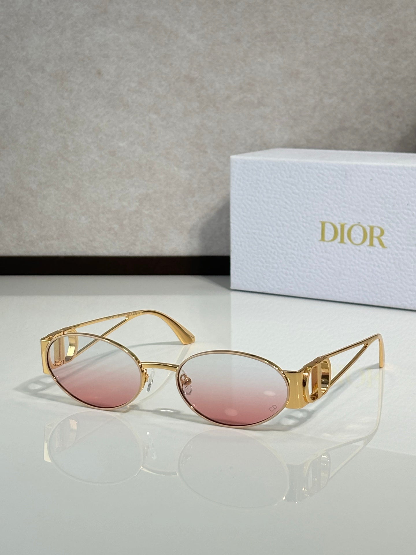 Gold-framed round sunglasses with pink tinted lenses