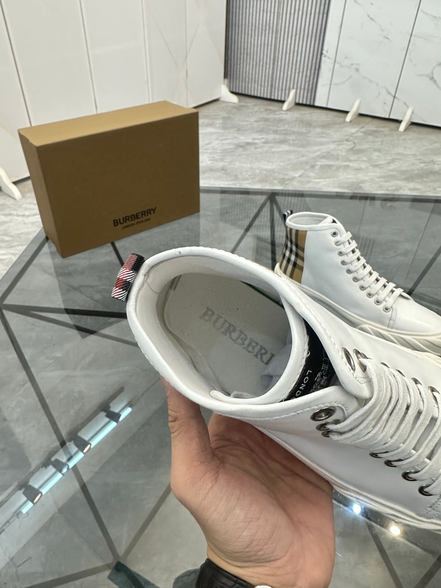 Burberry white high-top sneaker shown with open collar and lace-up front
