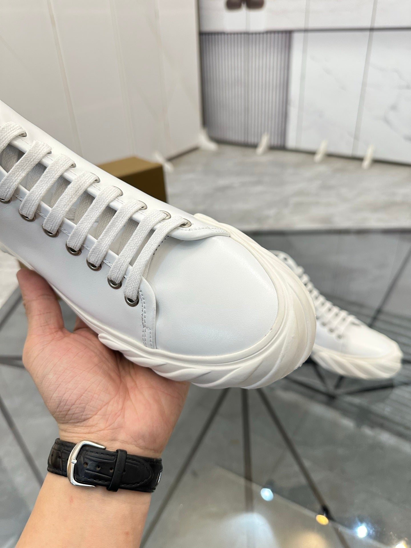 Burberry white leather high-top sneaker close-up of laces, side stitching, and toe