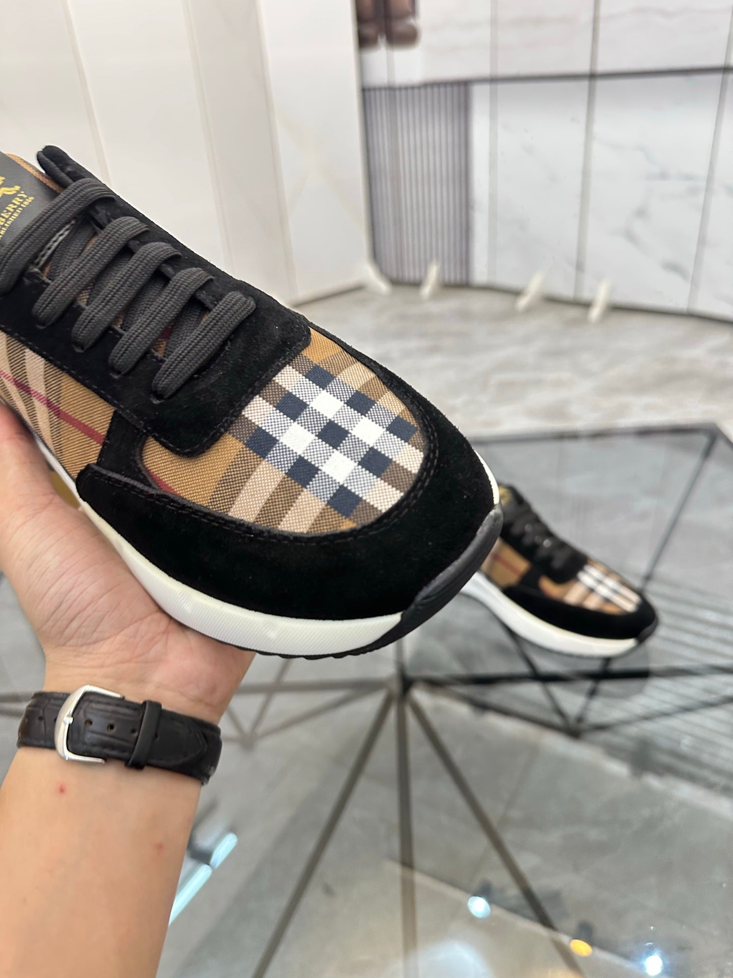 Burberry sneaker side view: black upper with tartan check inserts and thick white midsole