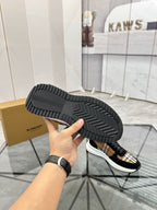 Burberry sneaker outsole view: black tread sole with tartan-lined upper