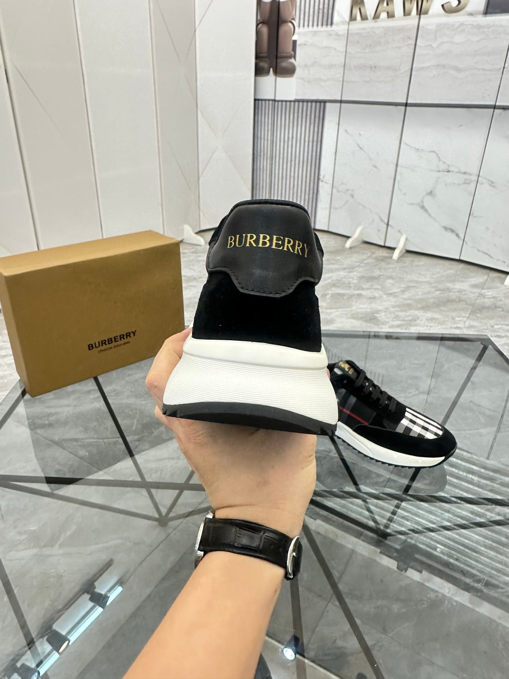 Burberry black lace-up sneakers viewed from the back, with logo tab and white sole