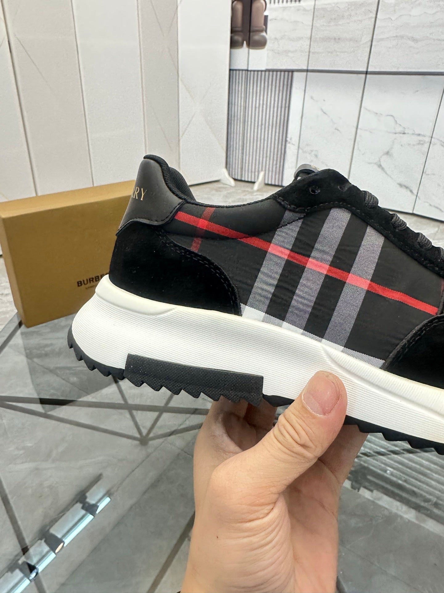 Burberry black sneaker with red and gray tartan stripe and thick white sole