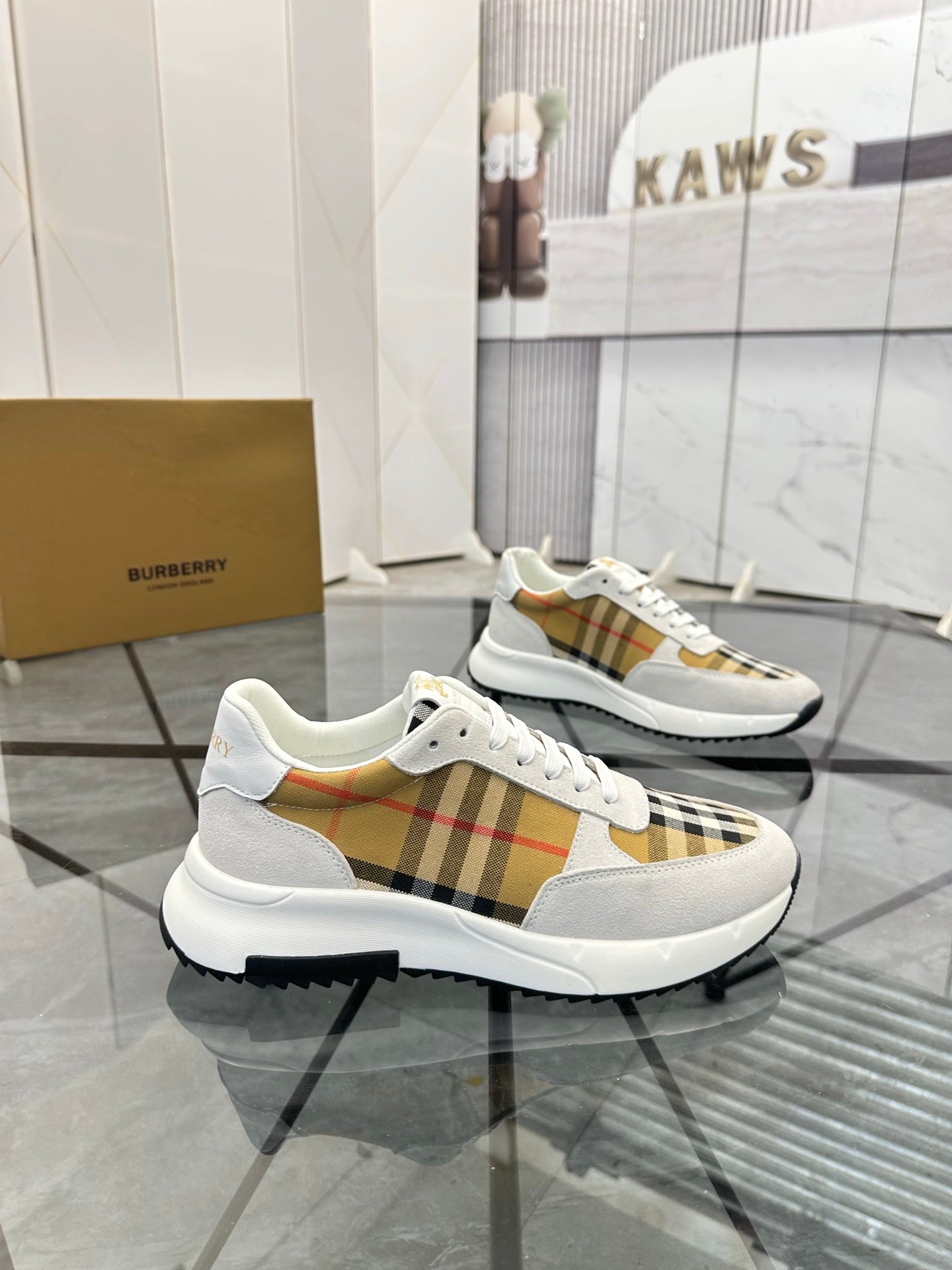 Pair of white lace-up sneakers with tan plaid panel details and chunky rubber sole