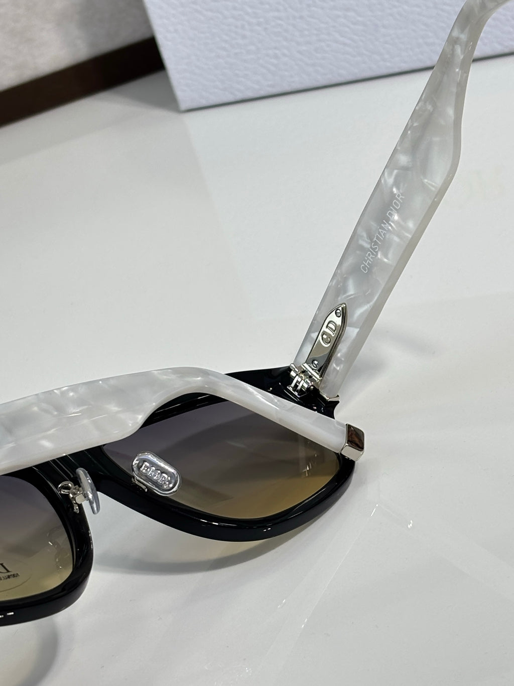 Dior sunglasses close-up: black temple with embossed logo and dark lens