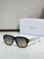 Dior sunglasses with black frames and dark-to-light lenses, gold Dior logo at temple