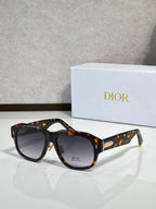 Dior sunglasses with dark tortoise frames, speckled accents, gold logo at temple