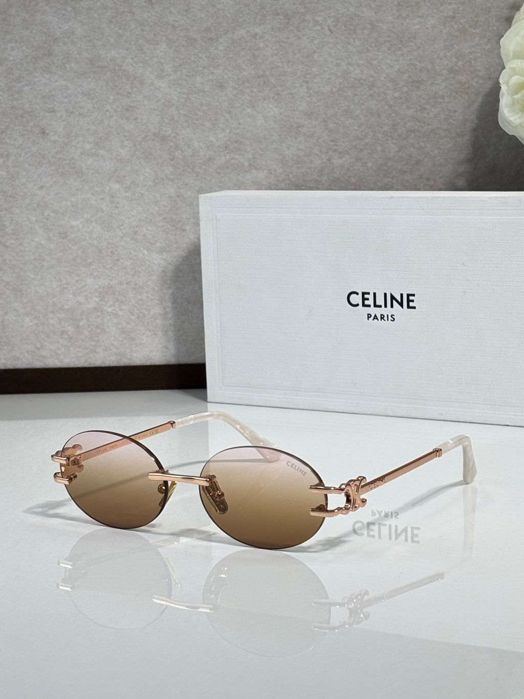 Celine sunglasses with light brown round lenses and rose-gold metal frame, clear tips