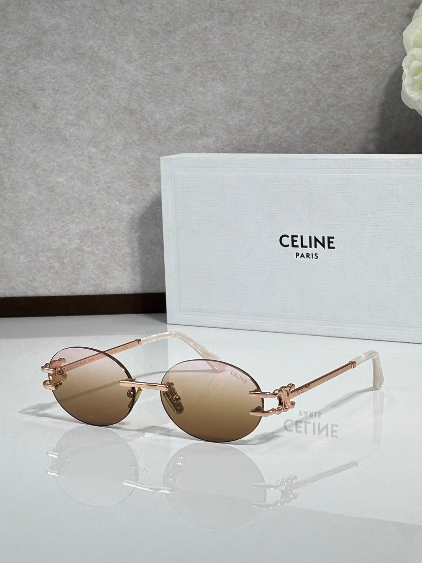 Celine sunglasses with light brown round lenses and rose-gold metal frame, clear tips