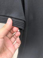 Black polo shirt sleeve cuff with ribbed trim detail.