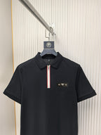 Black short-sleeve polo shirt with striped zip pull and chest logo.